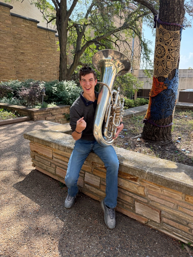 Jack Stutler laughing while holding his tuba outdoors